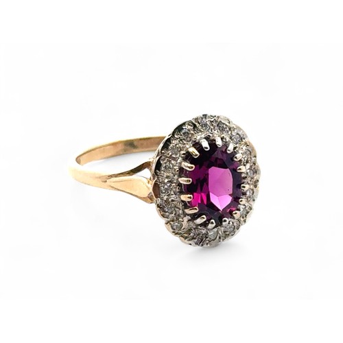 6 - A 9ct yellow and white gold dress ring set with a purplish - red oval rhodonite garnet surrounded by... 