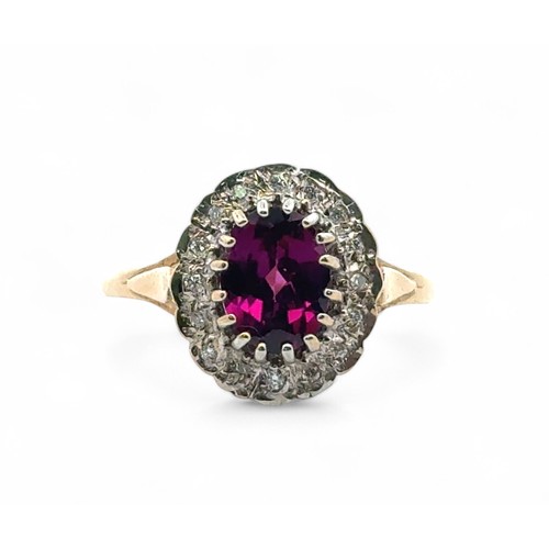 6 - A 9ct yellow and white gold dress ring set with a purplish - red oval rhodonite garnet surrounded by... 