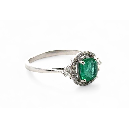 48 - An 18ct white gold emerald and diamond cluster ring with diamond shoulders, size N. Emerald approx 0... 