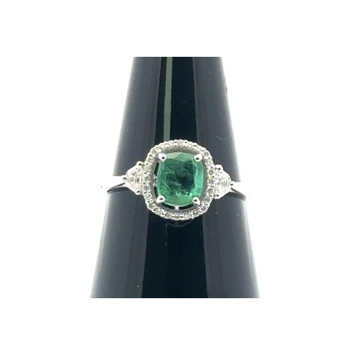 48 - An 18ct white gold emerald and diamond cluster ring with diamond shoulders, size N. Emerald approx 0... 