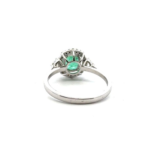 48 - An 18ct white gold emerald and diamond cluster ring with diamond shoulders, size N. Emerald approx 0... 