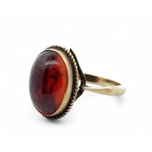 102 - A 9ct yellow gold ring set with a red stone in a rope twist surround, size N. 3.1g.