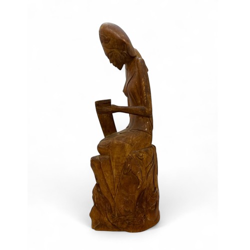 345 - Balinese carved wooden sculpture of a seated lady signed IWAJANWIRI MAS BALI to base. Height 37cm.