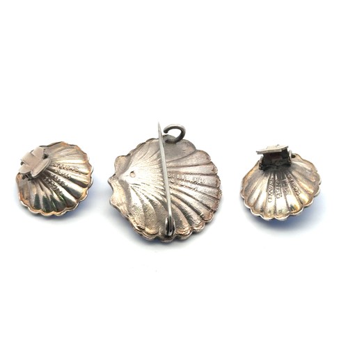 93 - A vintage silver and blue enamel pixie in a scallop shell brooch, with matching clip on earrings. Un... 