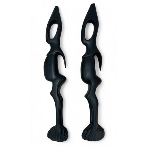 353 - A pair of West African tall standing ebony abstract female figurines, with hollow heads. One having ... 