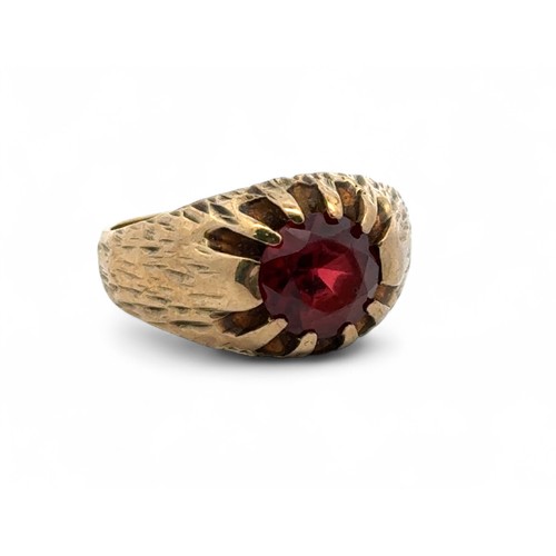 34 - A 9ct gold and garnet ring with sunburst setting and bark effect shank. Size L. 4.5g