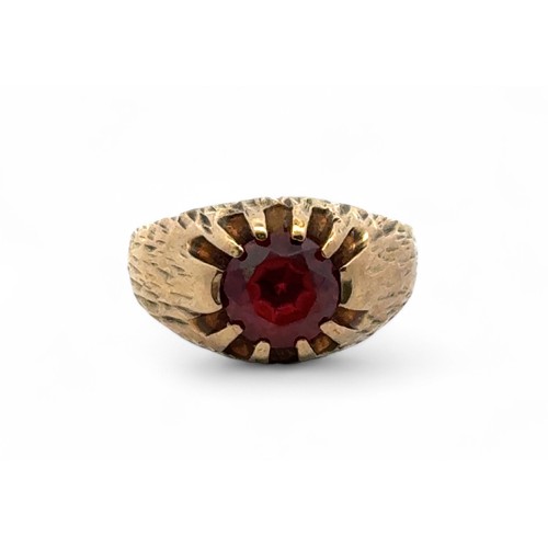 34 - A 9ct gold and garnet ring with sunburst setting and bark effect shank. Size L. 4.5g