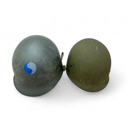 62 - Second World War US M1 helmet and liner, fixed chinstrap bails with fitted chinstrap with blackened ... 