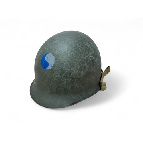 62 - Second World War US M1 helmet and liner, fixed chinstrap bails with fitted chinstrap with blackened ... 