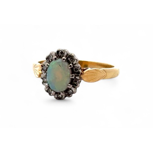 25 - An opal and diamond cluster ring, stamped 18ct. Size L.  3.9g.