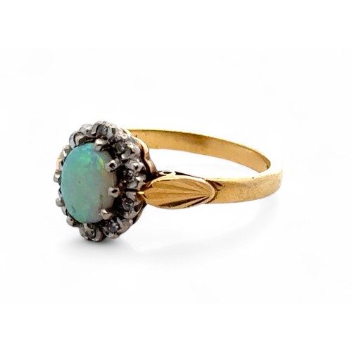 25 - An opal and diamond cluster ring, stamped 18ct. Size L.  3.9g.