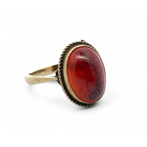 68 - A 9ct yellow gold ring set with a red stone in a rope twist surround, size N. 3.1g.