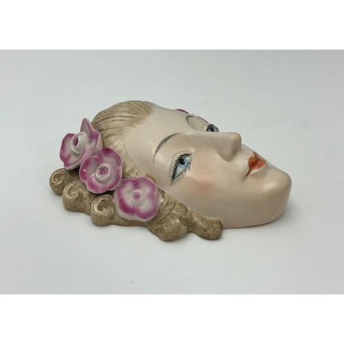 352 - Goebel, an Art Deco ceramic wall mask modelled as a lady with curled hair and flowers in her hair. I... 