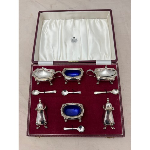 127 - A cased Garrard & Co Ltd six piece silver cruet set with blue glass liners. Birmingham 1968.