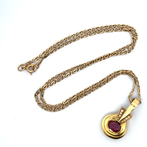 46 - A ruby and yellow gold pendant with a chain stamped 750. necklace.  Pendant is unmarked but tests as... 