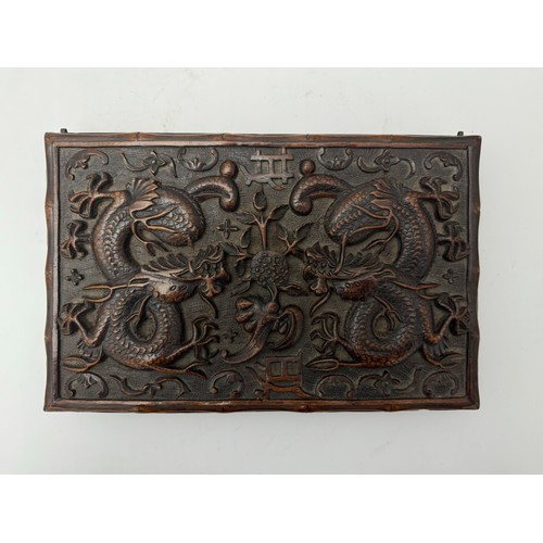 293 - Chinese carved wooden box with dragon design to lid, lid on hinges. Height 5cm, length 31cm, depth 2... 