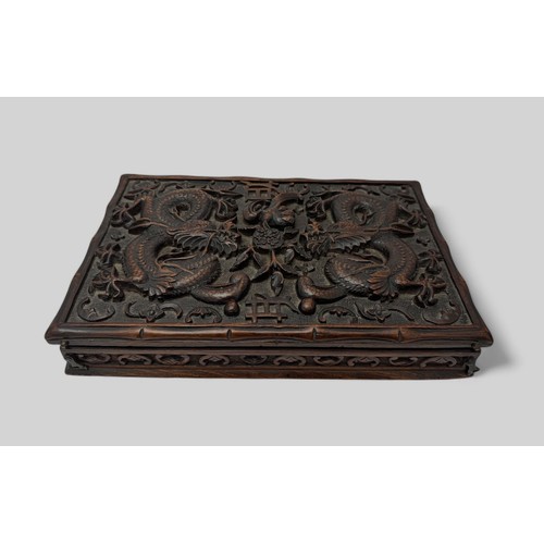 293 - Chinese carved wooden box with dragon design to lid, lid on hinges. Height 5cm, length 31cm, depth 2... 