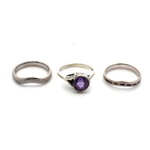 53 - A bespoke set of three rings designed to be worn together. Including an amethyst and diamond cluster... 