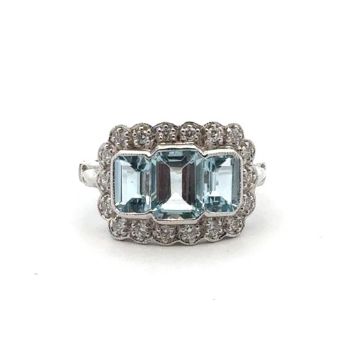 27 - An 18ct white gold aquamarine and diamond ring, size M/N. Set with emerald-cut aquamarines surrounde... 