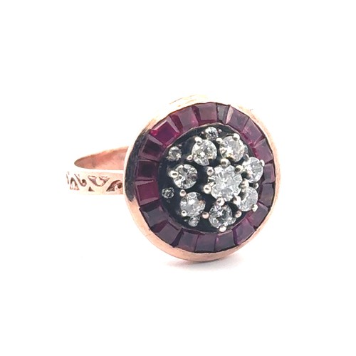 52 - A rose gold target style ring set with diamonds and rubies with patterned shoulders. Rubies 0.85ct a... 