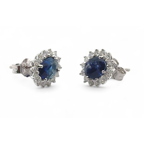 45 - A pair of 18ct white gold oval sapphire and diamond cluster stud earrings.  Sapphires approx 1.9ct, ... 