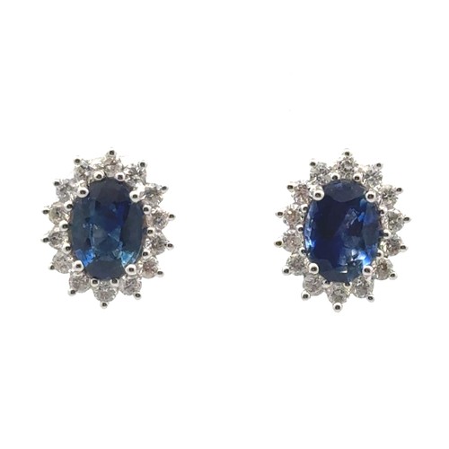 45 - A pair of 18ct white gold oval sapphire and diamond cluster stud earrings.  Sapphires approx 1.9ct, ... 