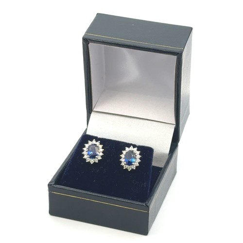 45 - A pair of 18ct white gold oval sapphire and diamond cluster stud earrings.  Sapphires approx 1.9ct, ... 