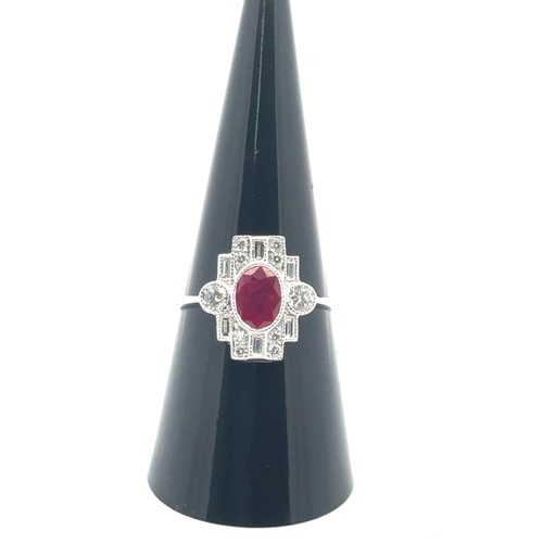 5 - An 18ct white gold Art Deco style ring set, size O/P.  Set with an oval ruby and with baguette and r... 