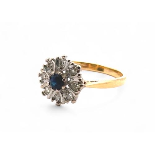 22 - A sapphire and diamond cluster style ring, stamped 18ct. Size N. 4.02g