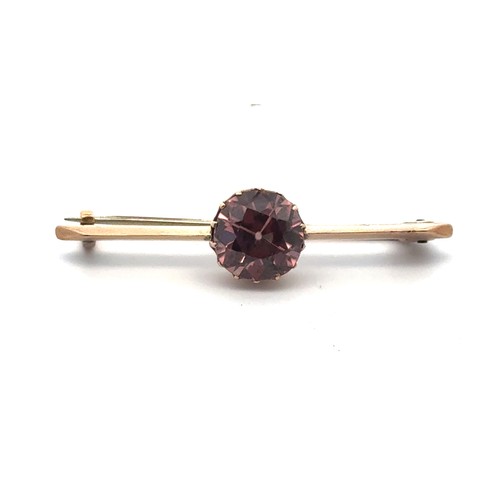 40 - A bar brooch set with a brownish pink zircon, approx 10mm in diameter,  in unmarked yellow metal. Le... 