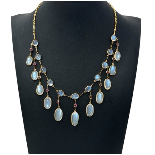 20 - A moonstone and garnet fringe necklace in unmarked yellow metal. Graduated vari-cut cabochon moonsto... 