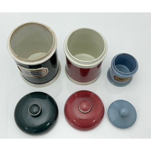 398 - Three Coloured Apothecary Jars: Largest, Dome topped Olive Green, raised ceramic gold foil label ADE... 