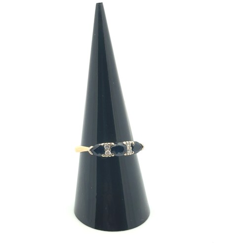 29 - A sapphire ring in 18ct gold with diamond accents, size P.