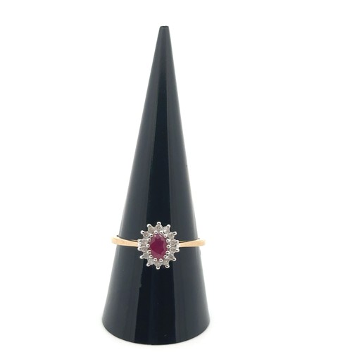 7 - An oval ruby and diamond cluster ring in 9ct gold, size R. 2.34g