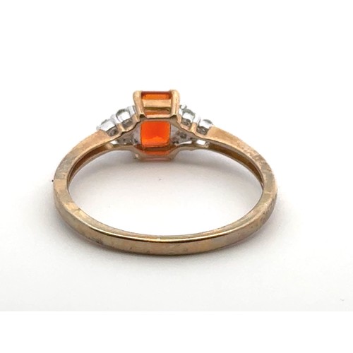 22 - An orange stone ring with diamond accents in 9ct gold, size R.