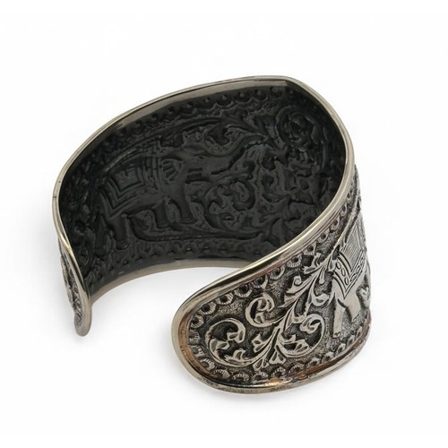 5 - An Indian repousse silver cuff bangle with elephant and foliate decoration. Stamped 'India dp' (Doug... 