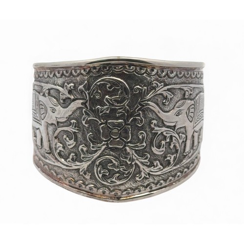 5 - An Indian repousse silver cuff bangle with elephant and foliate decoration. Stamped 'India dp' (Doug... 