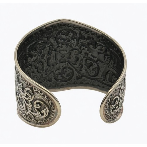 5 - An Indian repousse silver cuff bangle with elephant and foliate decoration. Stamped 'India dp' (Doug... 