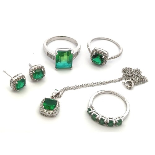 26 - Silver and green stone jewellery items. Includes a matching ring, earrings and necklace set, an emer... 