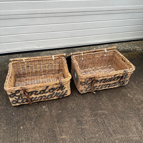 669 - Two Large Wicker Baskets. London Laundry. Leather fastening straps. H31cm x W69cm x D48cm. Qty 2. BU... 