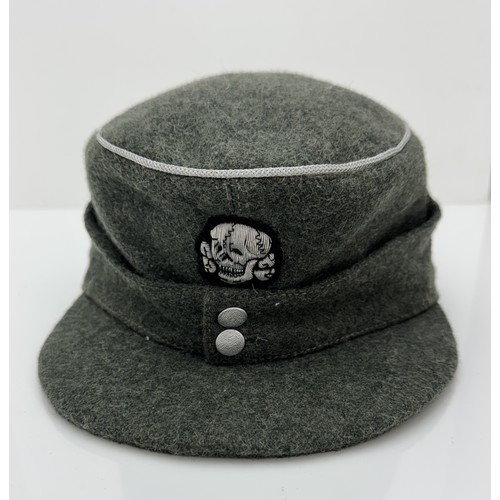 63 - Two reproduction WWII German caps. A reproduction  'SS' M43 field cap with good quality insignia, si... 