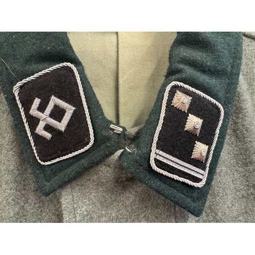 65 - A reproduction SS Officer's Tunic with badges and insignia. 44