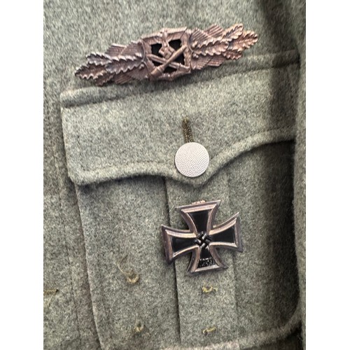 65 - A reproduction SS Officer's Tunic with badges and insignia. 44