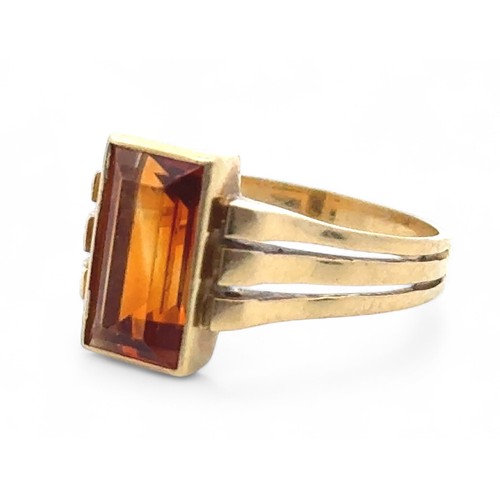 4 - A rectangular citrine ring, bezel set in a yellow metal mount stamped 750, size  N. 5.11g