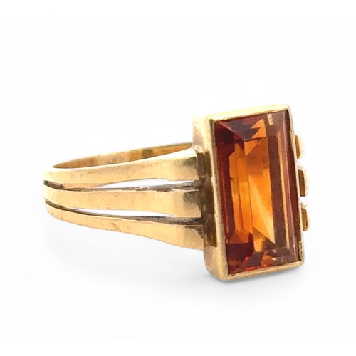 4 - A rectangular citrine ring, bezel set in a yellow metal mount stamped 750, size  N. 5.11g