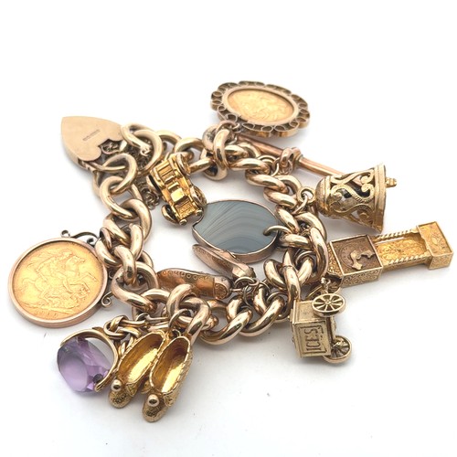 20 - A 9ct gold charm bracelet with eleven charms including a full sovereign and a half sovereign. Some c... 