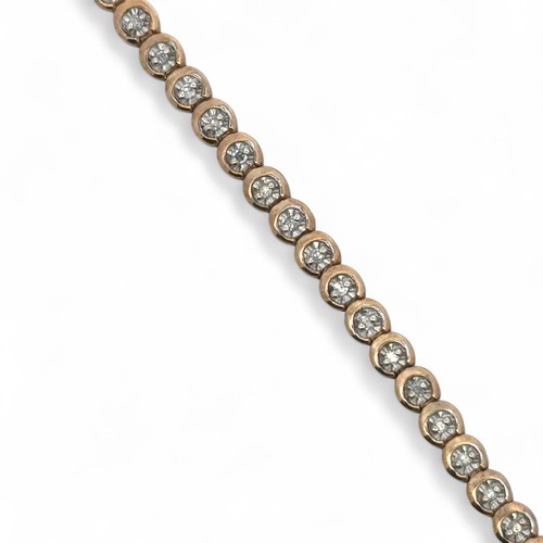 52 - A 9ct gold and illusion set diamond tennis bracelet, stamped 375 and CCM mark, sponsor SG. Approx 18... 
