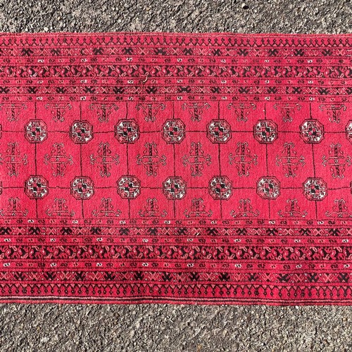 A long Afghan Mauri runner rug with Bokhari design, deep red ground ...