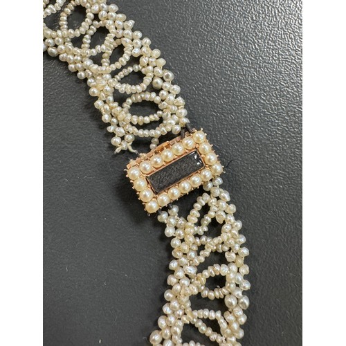 8 - A Georgian seed pearl necklace. Yellow metal with seed pearls surrounding a glazed hairwork panel. C... 