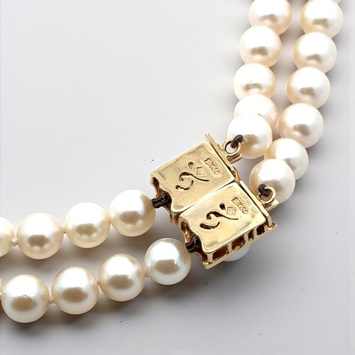 30 - A double strand uniform cultured pearl necklace with an 18ct yellow gold and diamond clasp. Can be d... 